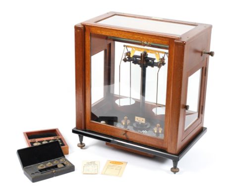A set of mid-20th century Gallenkamp (London) scales in glazed case, together with two cased sets of weights, 46 cm x 39 cm