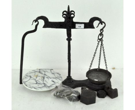A set of early 20th century cast iron dairy scales, with marbled ceramic plate to one side and metal dish the other; together