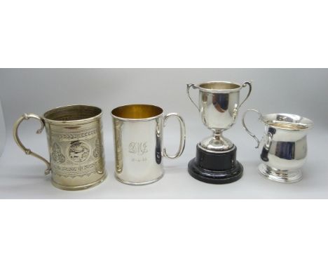 A silver mug, a small silver tankard, both Birmingham 1931, 149g total, a silver trophy, 11.5cm including stand, and an engra