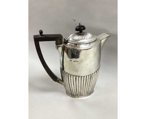 A Hallmarked Silver Hot Water Pot, Messrs Hutton, London 1902, of semi reeded form (spout wear / damage) (525grams).