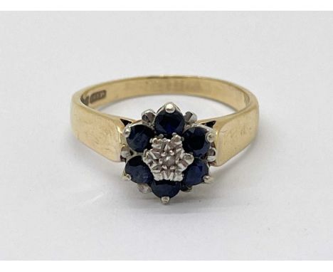 A 9ct Gold Sapphire Cluster Ring, of flowerhead design, between wide plain shoulders (finger size N).