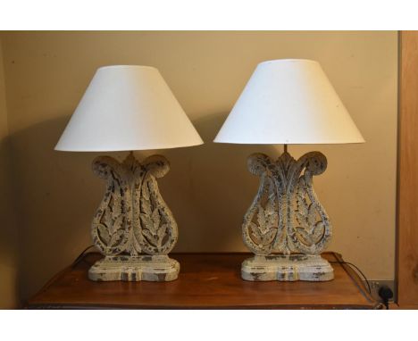 A pair of contemporary distressed, painted, pierced and carved table lamps with foliate decoration. H.69 W.29cm (inc. shade) 