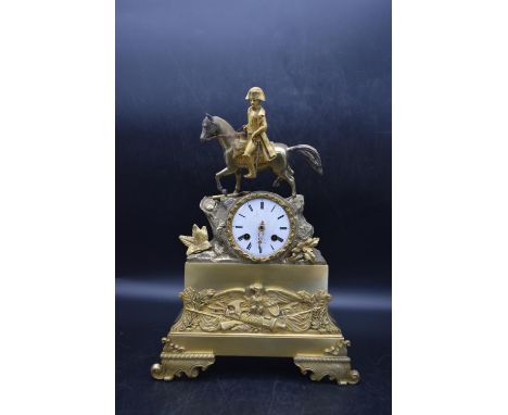 A late 19th century French gilt metal mantle clock with a white dial, decorated with a Napoleon soldier situated on top, and 