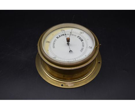 A 19th century brass rivet style Aneroid Barometer with a white enamel dial. H.24 W.24 D.12cm