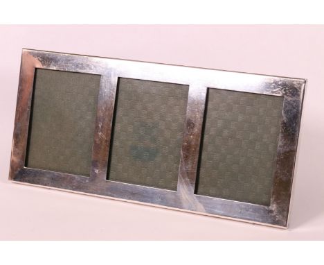 A sterling silver triple aperture easel back photograph frame, marked sterling to the base.