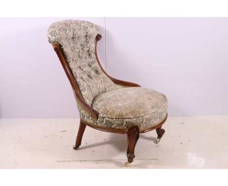 Antique framed nursing chair with button back, scroll carved back and front legs, on casters, H 78cm
