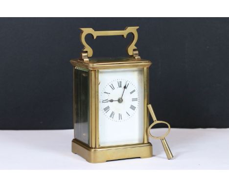 An early 20th century brass cased carriage clock with beveled glass panels and white enamel dial. 