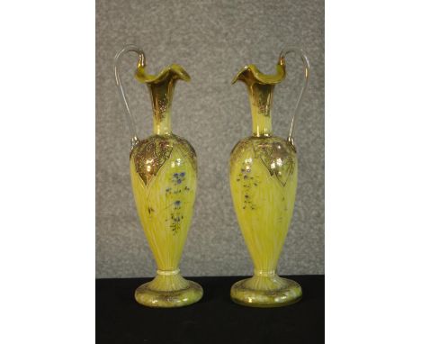 A pair of 19th century Bohemian gilded and enamel handled yellow and white marbled glass ewers with floral design. H.32 W.10 