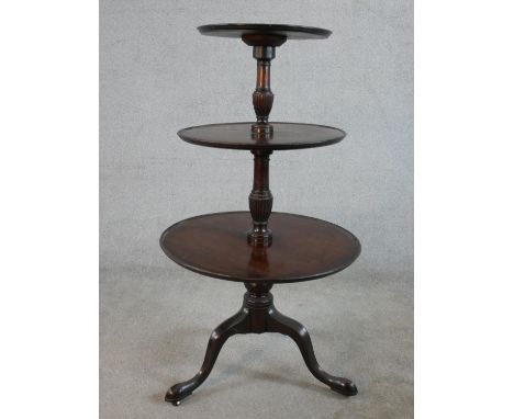 A 19th century mahogany three tier dumb waiter with carved central column raised on tripod base terminating in pad feet. H.11