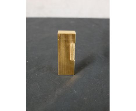 A 20th century gold plated Dunhill lighter, with fluted all over design. H.6.5 W.2.5 D.6cm 
