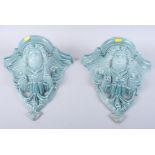 A pair of Continental blue glazed pottery cherub mask wall brackets, 12" high