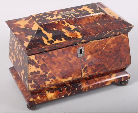 An early 19th century tortoiseshell two-division tea caddy, on bun feet, 7 1/2" wide