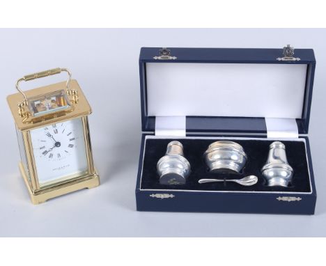 A gilt cased carriage clock with white enamel dial and Roman numerals, inscribed "Taylor and Bligh", and a boxed silver cruet