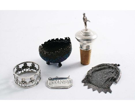 A MIXED LOT:- A modern mounted bottle cork with a jockey finial, a "BRANDY" label, an Indian napkin ring, an Indian chased sa