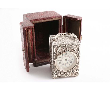 A LATE VICTORIAN EMBOSSED CARRIAGE TIMEPIECE with a decorated, cream coloured dial & black Roman numerals, the rectangular ca