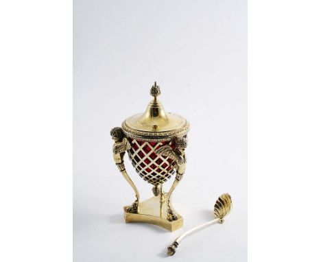 A VICTORIAN SILVERGILT OPEN WORK SUGAR VASE with winged caryatid supports, a red glass liner, domed cover and matching spoon,