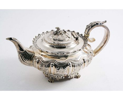 A GEORGE IV SQUAT CIRCULAR TEA POT with embossed stiff leaf decoration around the sides, foliate paw feet and a flower finial