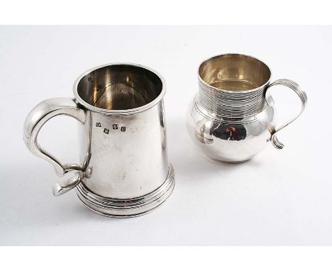 A MODERN IRISH MUG of tapering form with a skirted base, by the Royal Irish Silver Company, Dublin 1970 and an Edwardian mug 