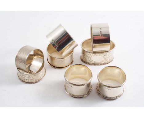 A PAIR OF VICTORIAN NAPKIN RINGS with fine bead borders, by W & J. Barnard, London 1882, two other late Victorian napkin ring