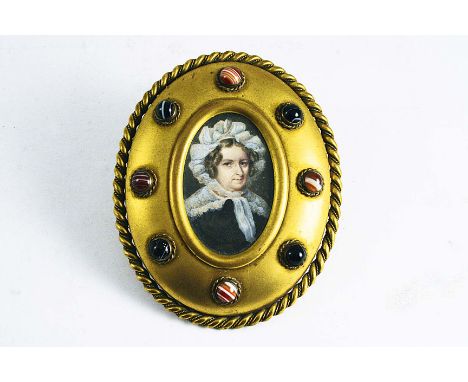 AN EARLY VICTORIAN GILT BRASS FRAME  set with agate bosses; 12.5 x 10 cms, containing a miniature portrait of a lady wearing 