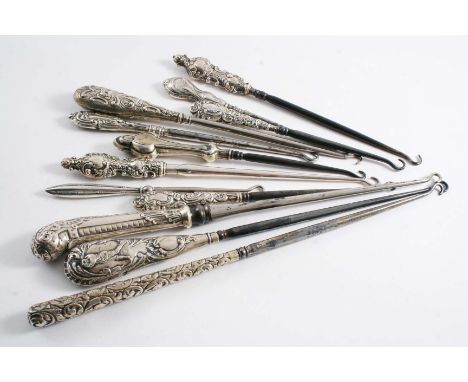 TWELVE VARIOUS ANTIQUE, MOUNTED STEEL BUTTON HOOKS (including one with a golfer on the handle in low relief), mixed makers & 