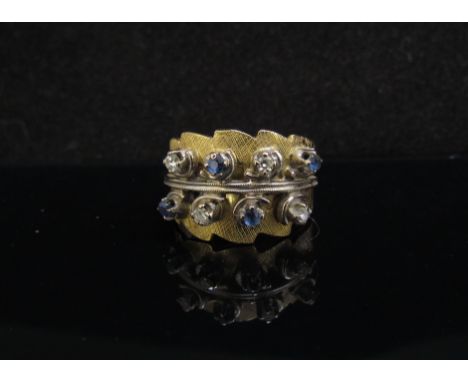 An 18ct gold wide band ring set with four diamonds and four sapphires. Size P, 9.3g