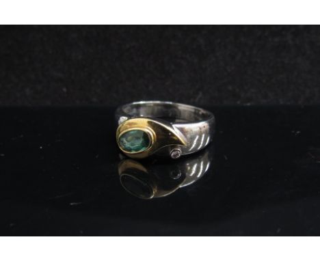 A white and yellow gold ring set with a green tourmaline and diamond in rubover setting, stamped 18k. Size R, 6.3g