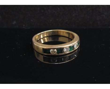 A gold diamond and emerald half hoop ring. Size N, 3.4g