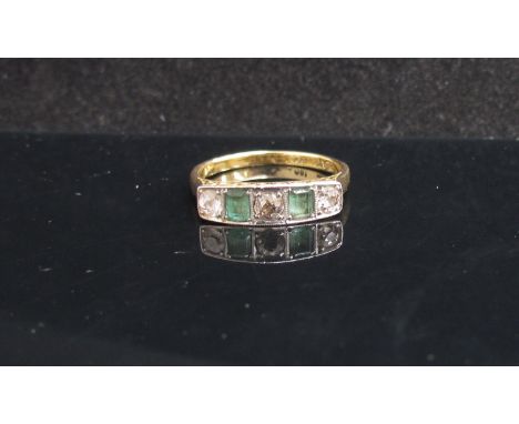 A gold platinum set emerald and diamond ring, stamped 18ct. Size P, 3.4g