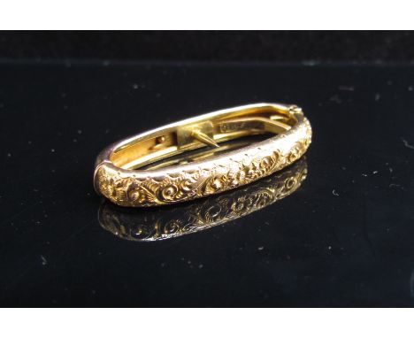 A gold scarf ring with scrolled foliate and floral relief stamped 9c, 2.6g