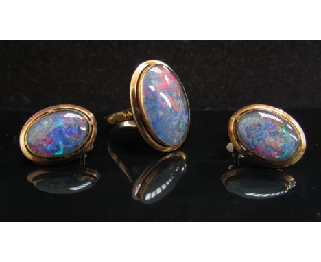 A black opal ring 20mm x 13mm in a gold shank stamped 18k. Size P with a similar pair of screw-back earrings stamped 14k (7.6