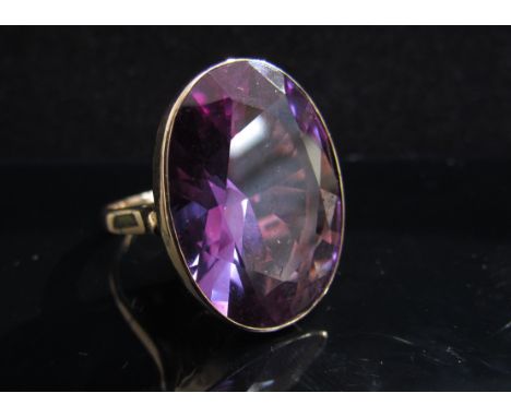 A gold ring set with a large blue/purple facet cut oval stone, 25mm x 18mm. Size Q, 14k, 11.1g