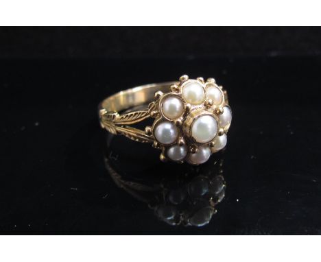 A 9ct gold pearl cluster ring in ornate open ''leaf'' shoulders. Size Q, 3.9g