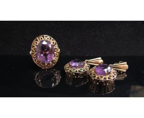 A gold ring set with an oval amethyst in fancy scroll mount, stamped 14c. Size Q and a pair of matching earrings, 11.8g