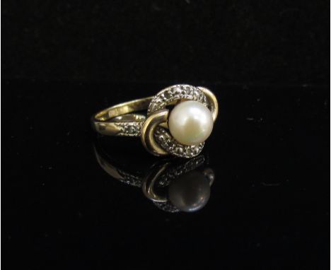 A 9ct gold ring centrally set with pearl with scroll diamond set mount. Size O, 3g