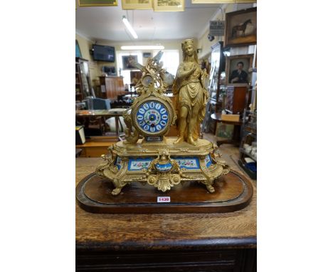 A Louis XVI style gilt spelter and Sevres style mantel clock, 38cm high, with pendulum, on stained pine stand and glass dome,