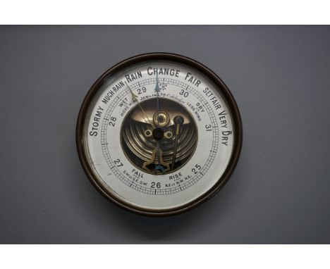 A brass aneroid barometer, the silvered dial inscribed 'Joslin Ltd, Colchester', 13.5cm diameter.&nbsp; 