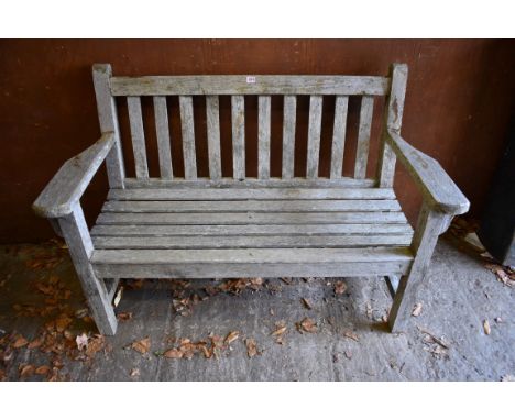 An old teak garden bench, 133cm wide x 63cm deep.Collection of this lot is strictly by appointment on Saturday 17th April bet