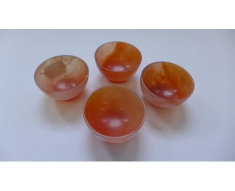 A set of four orange mottled miniature jade bowls.  (4)  2.4 x 5cm