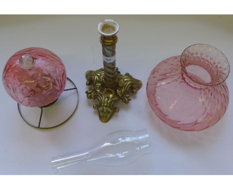 A brass and cranberry glass oil lamp