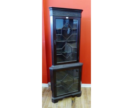 A late 19th century mahogany corner cabinet having astragal glazed panel doors enclosing shelved interior raised on bracket f