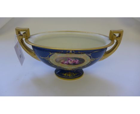Royal Worcester twin handled pedestal vase, the blue ground with handpainted floral cartouche within a gilt scrolling border,