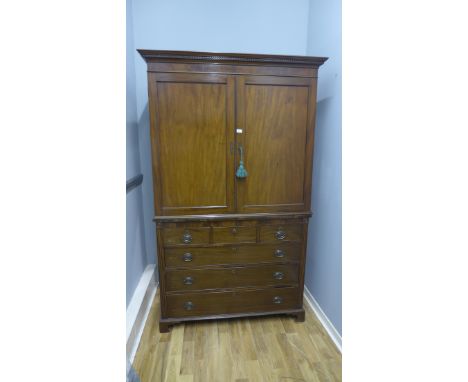 A 19th Century mahogany linen press, having two panel doors enclosing shelved interior, above three short and three long draw