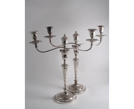 A PAIR OF OLD SHEFFIELD PLATED THREE-LIGHT CANDELABRA with round bases, scroll branches, fluted tapering column s & urn-shape