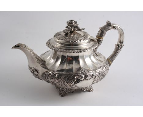 A GEORGE IV EMBOSSED TEA POT on four floral feet with a flower finial, a floral border & two vacant cartouches, by Richard Pe