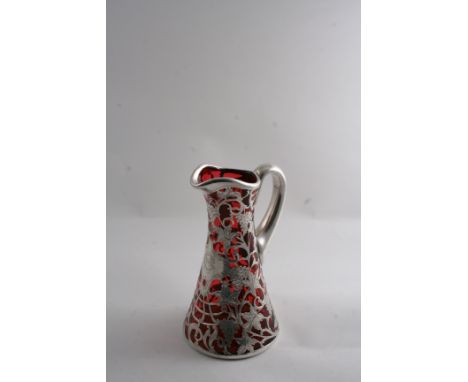 A LATE 19TH CENTURY AMERICAN ART NOUVEAU OVERLAID RUBY GLASS JUG OR PITCHER, the flaring body with engraved fruiting vines & 