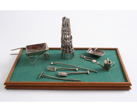 A CONTEMPORARY COLLECTION OF MINIATURE OR TOY GARDENING TOOLS/IMPLEMENTS INCLUDING: a woven cane tower, a wheelbarrow, a trug