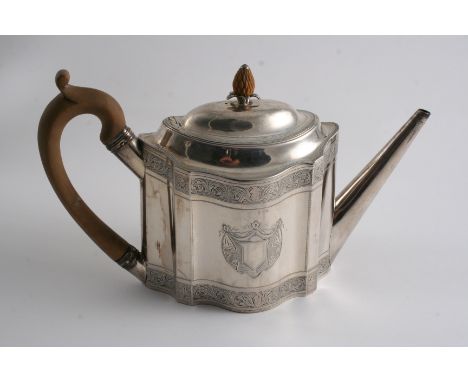 A GEORGE III PROVINCIAL BRIGHT-CUT TEA POT of shaped oval outline with a straight spout, domed cover & a vacant shield cartou