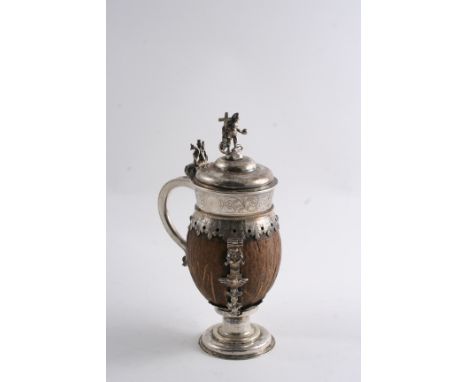 A 16TH CENTURY CONTINENTAL ENGRAVED MOUNTED COCONUT TANKARD with three decorative cast straps, a low domed foot and cover and