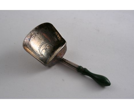 A GEORGE III CADDY SPOON in the form of a shovel or scoop with a green-stained, turned ivory handle & a vacant shield cartouc